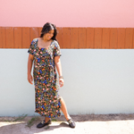 Woman wearing garden-floral jersey midi dress with side tie and square scoop neckline