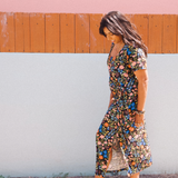 Woman wearing garden-floral jersey midi dress with side tie and square scoop neckline