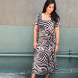 Model in zebra-print jersey midi dress featuring a side tie and two hem slits
