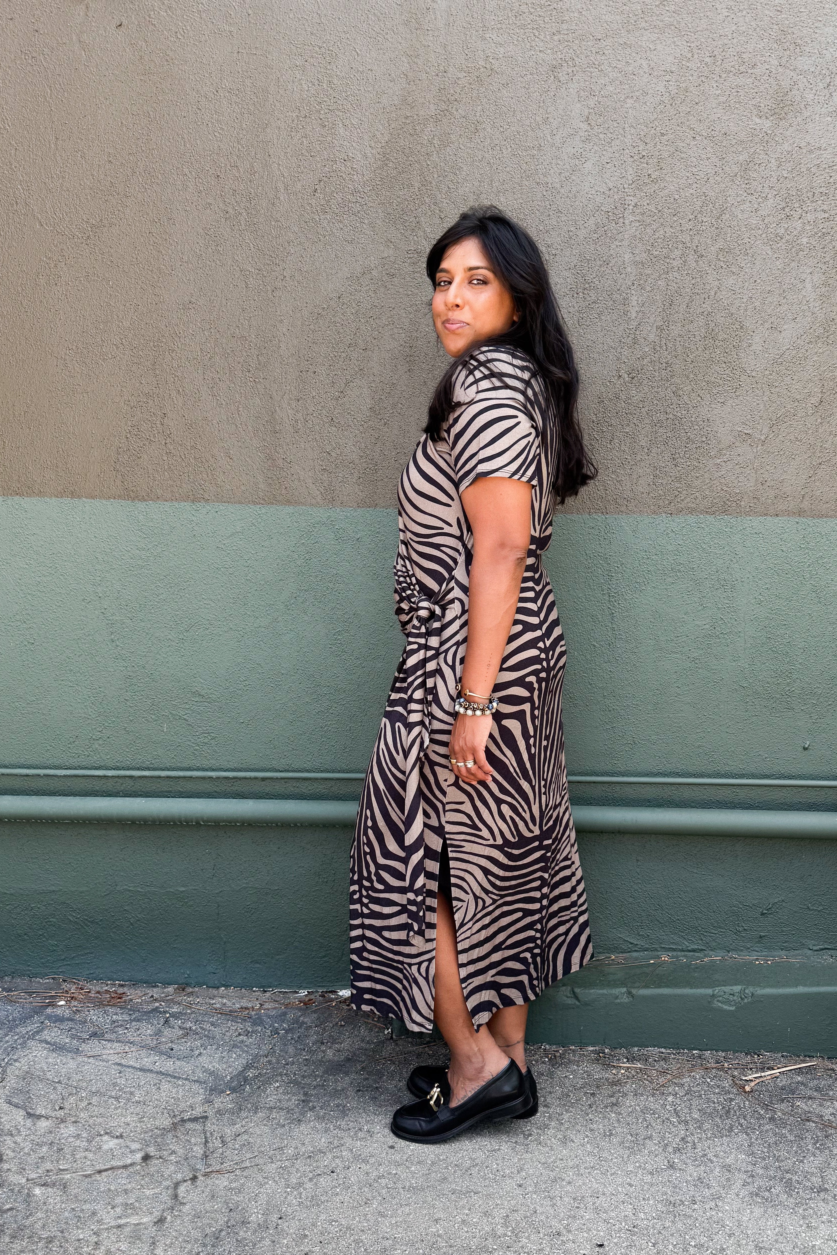 Model in zebra-print jersey midi dress featuring a side tie and two hem slits