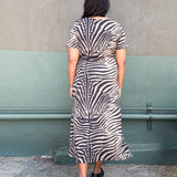 Model in zebra-print jersey midi dress featuring a side tie and two hem slits