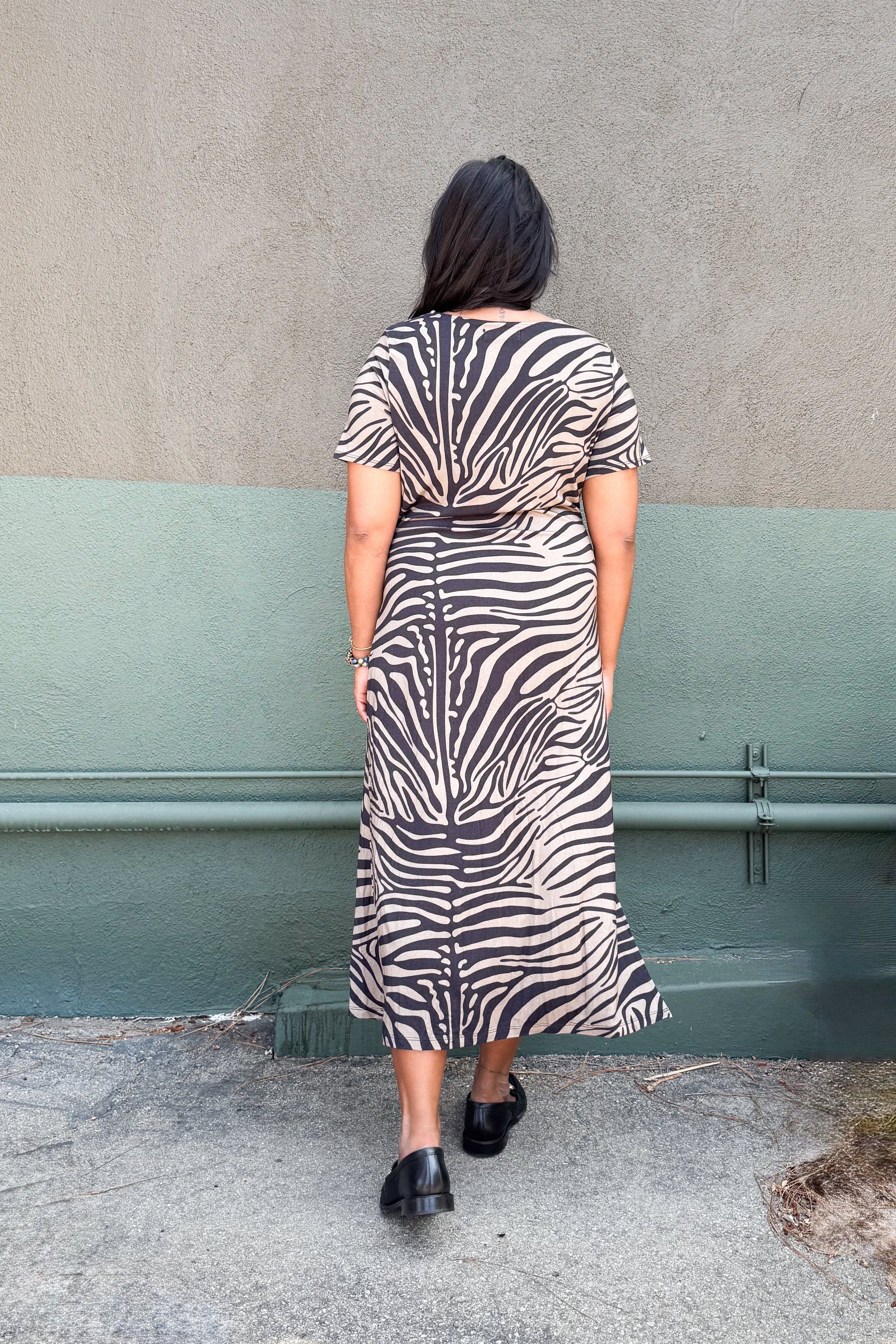 Model in zebra-print jersey midi dress featuring a side tie and two hem slits