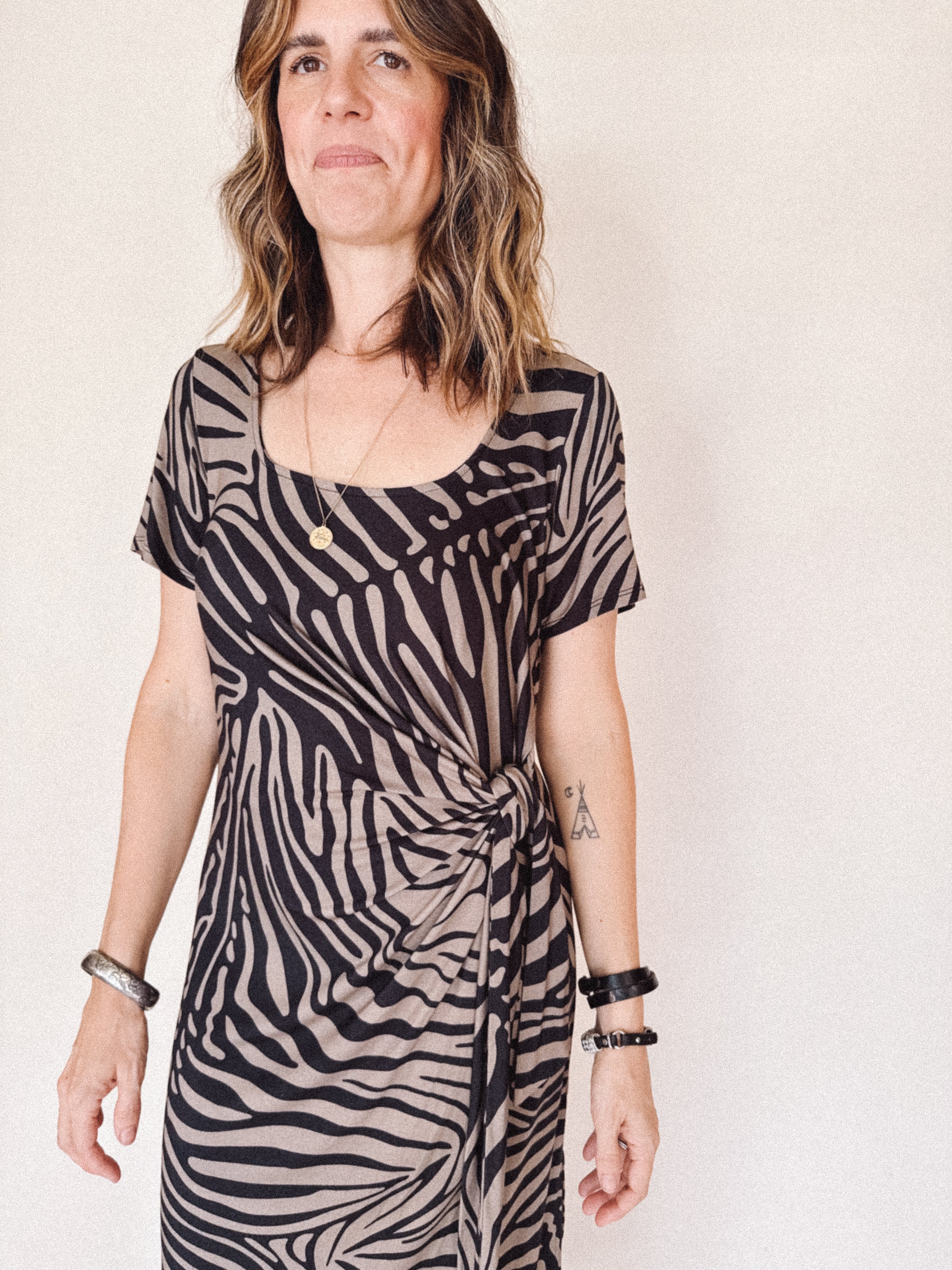 Woman wearing a zebra print dress against a plain background