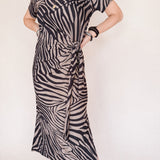Person wearing a zebra print dress against a white background