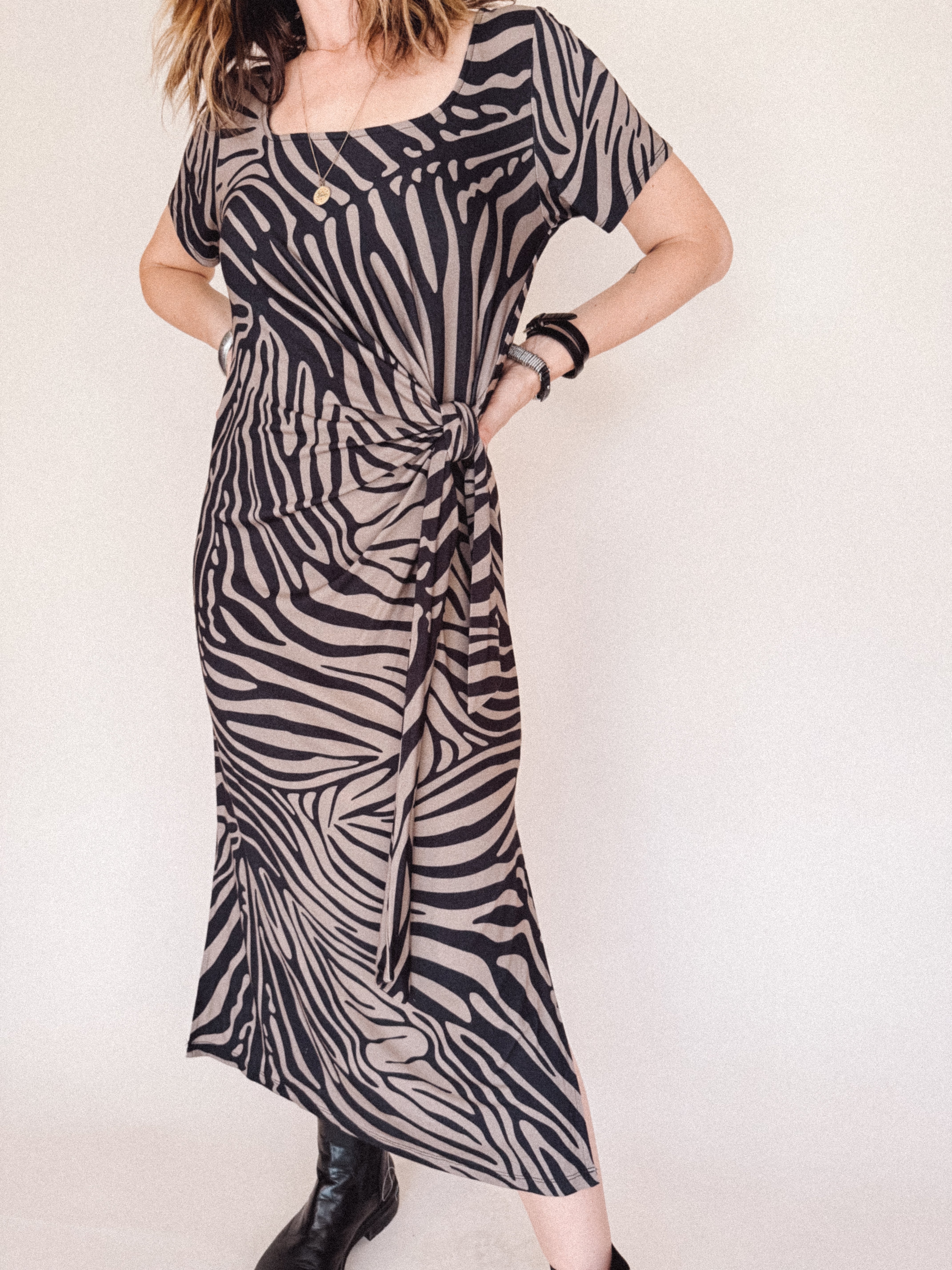 Person wearing a zebra print dress against a white background