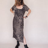 Woman wearing a zebra pattern dress on a white background