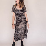 Woman wearing a zebra print dress against a plain background