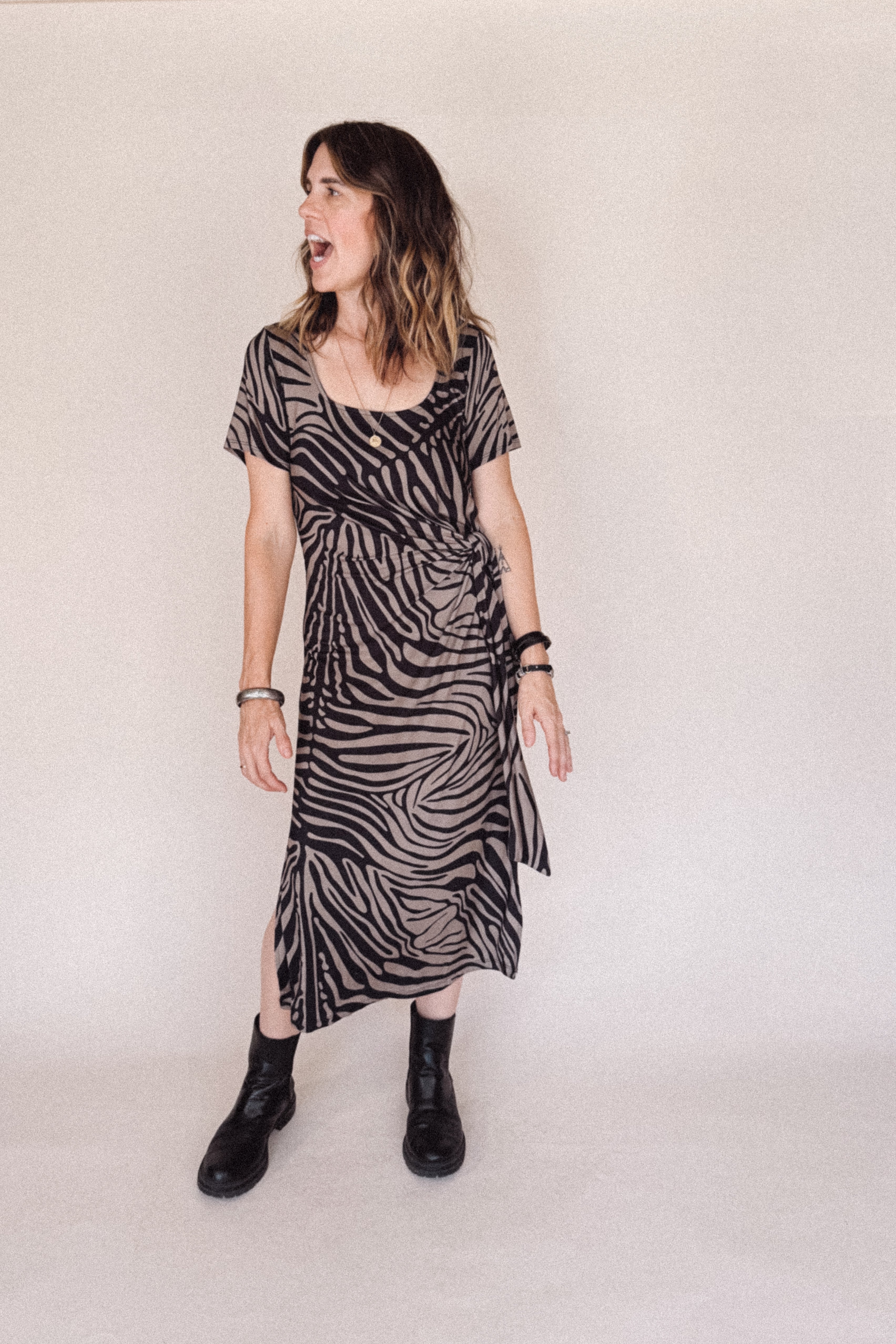Woman wearing a zebra print dress against a plain background
