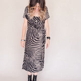 Person wearing a zebra print dress with a plain background
