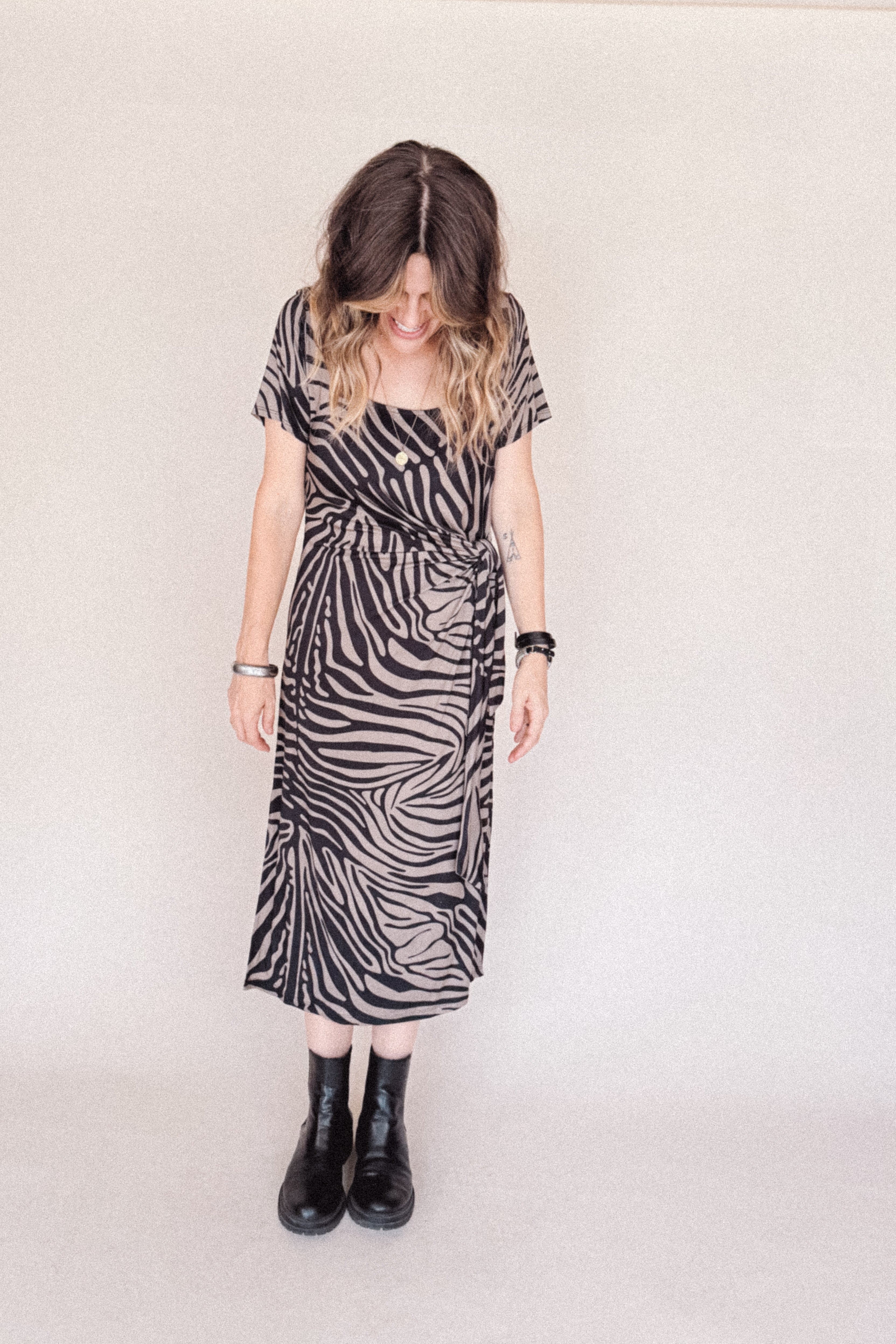 Person wearing a zebra print dress with a plain background
