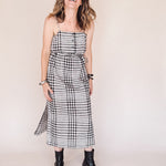 Woman wearing a black and white checkered dress against a plain background