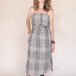 Woman wearing a black and white checkered dress against a plain background