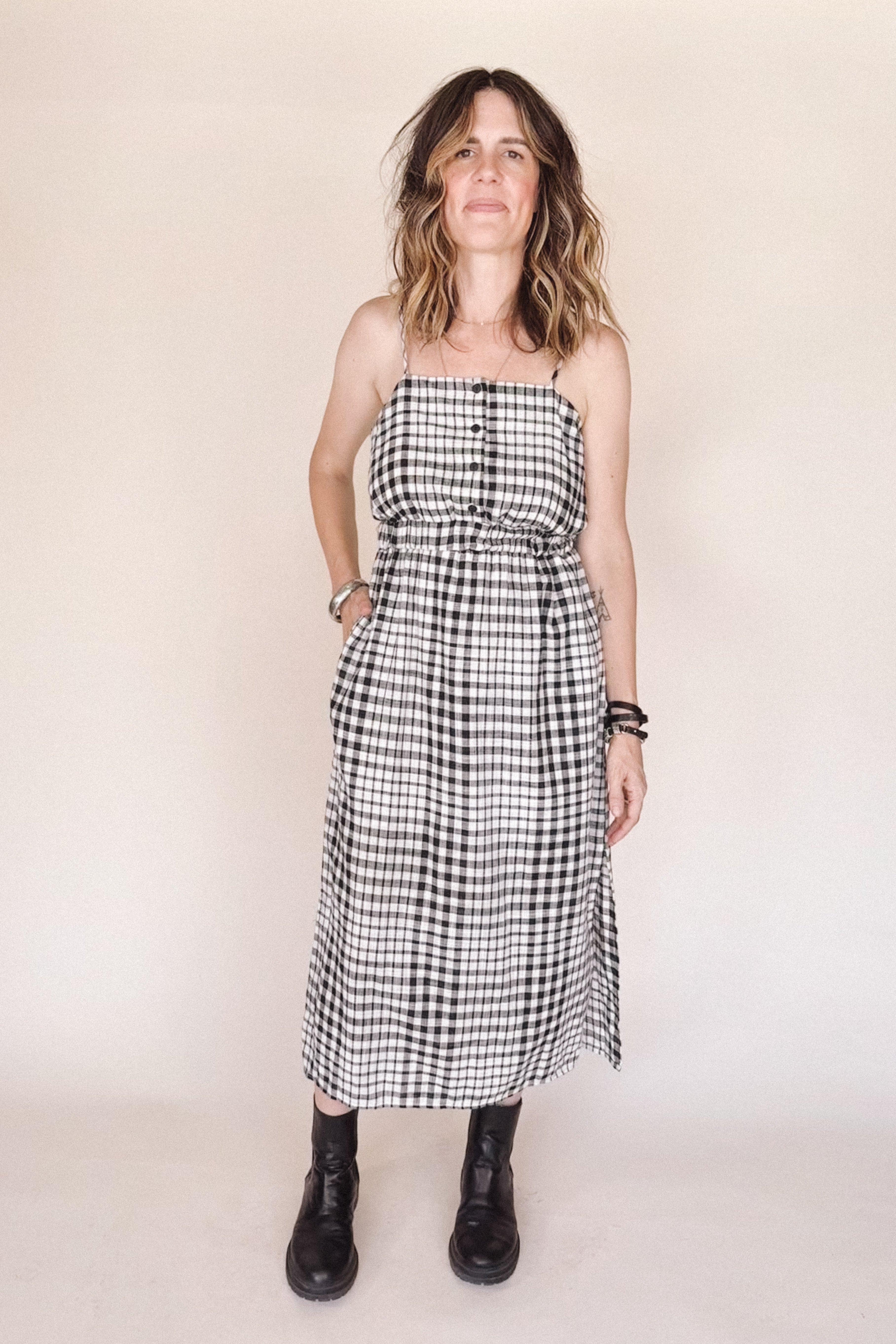 Woman wearing a black and white checkered dress against a plain background