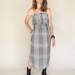 Woman wearing a black and white checkered dress against a plain background