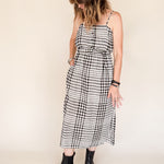 Woman wearing a black and white checkered dress on a beige background