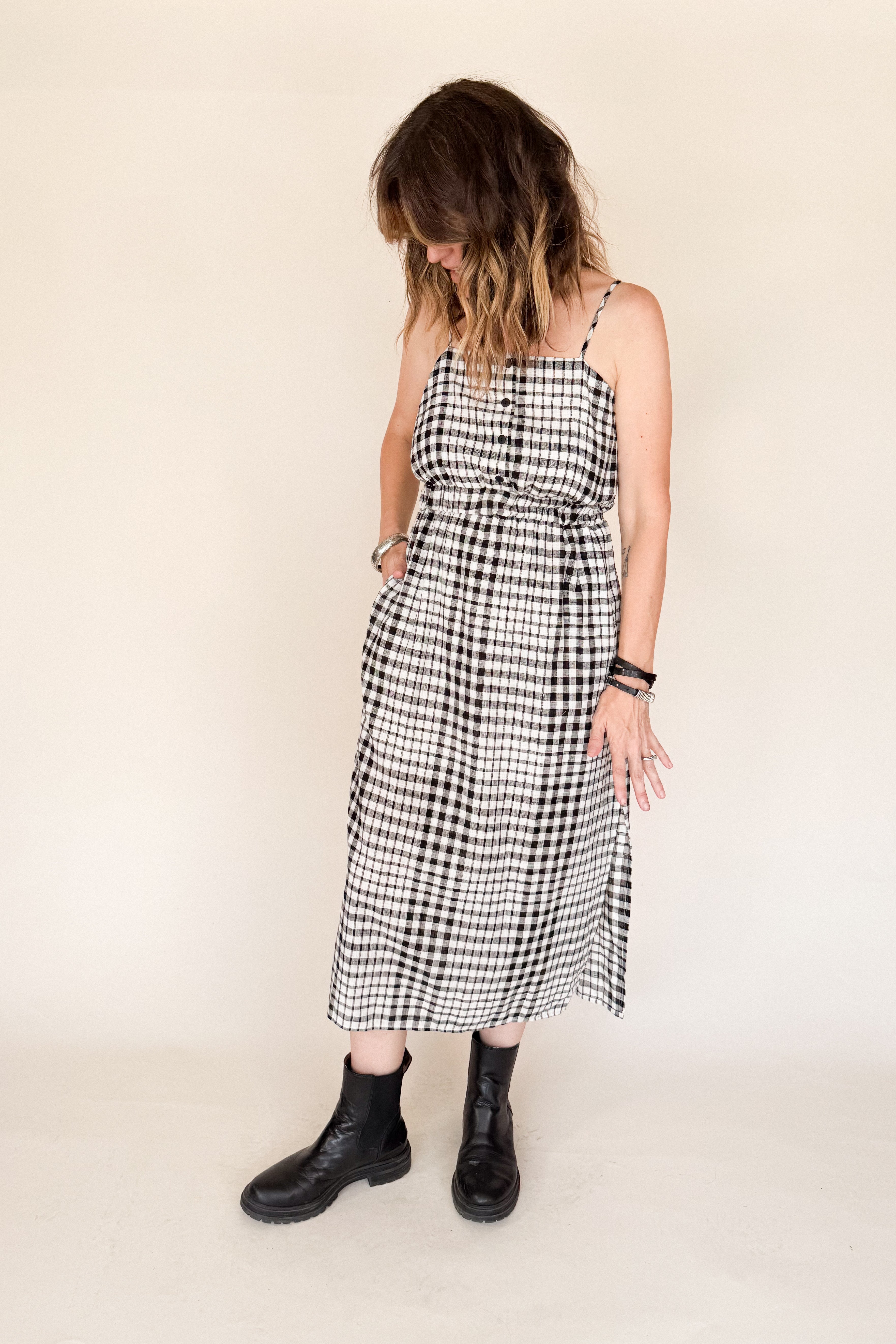 Woman wearing a black and white checkered dress on a beige background