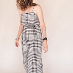 Woman wearing a black and white checkered dress against a plain background