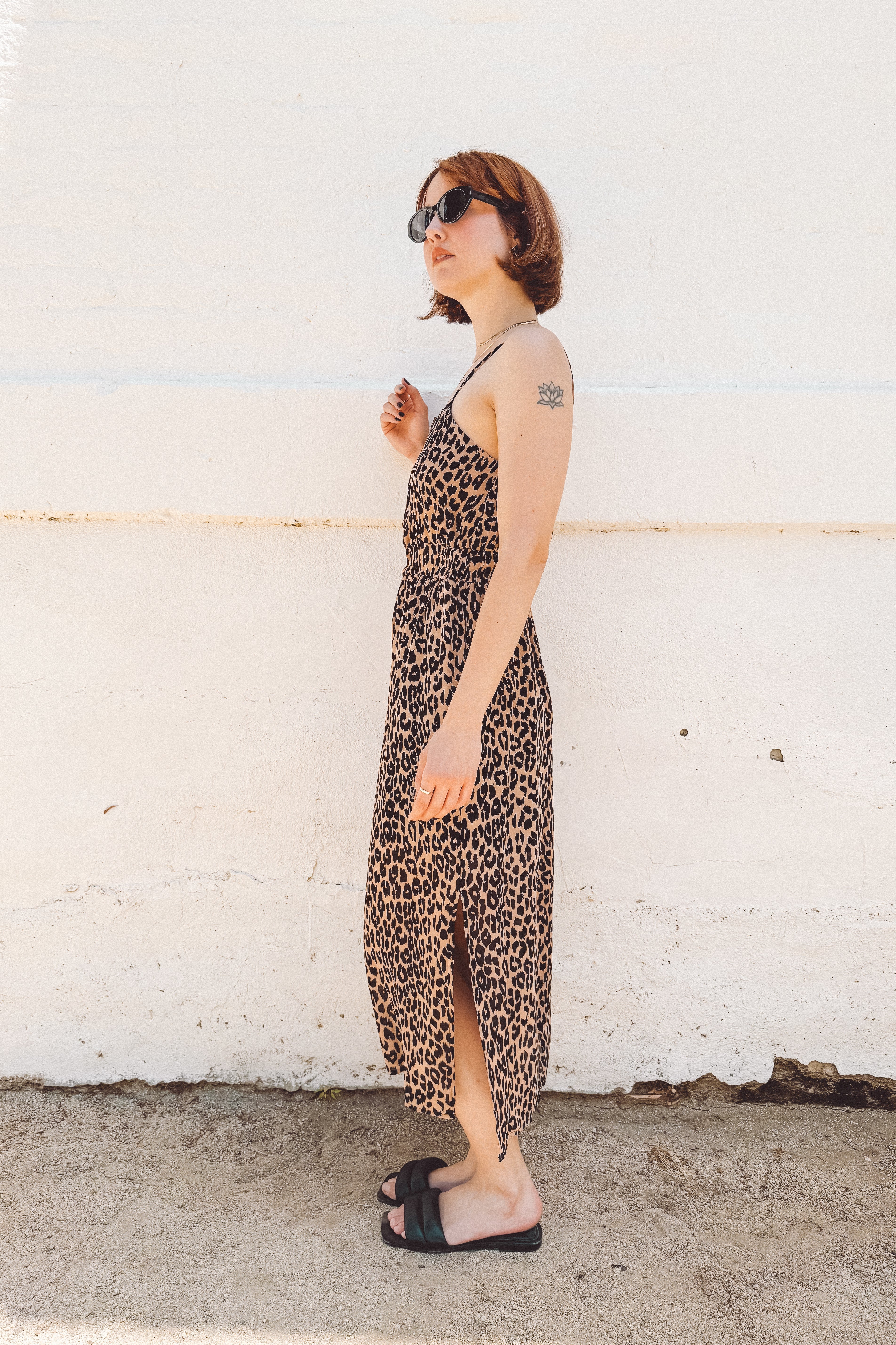 girl with short red hair wearing leopard print midi dress with side slits