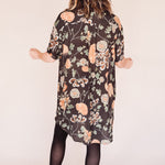 Woman wearing crane-print short sleeve button-up mini shirt dress with collar and side pockets, back