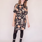 Woman wearing crane-print short sleeve button-up mini shirt dress with collar and side pockets
