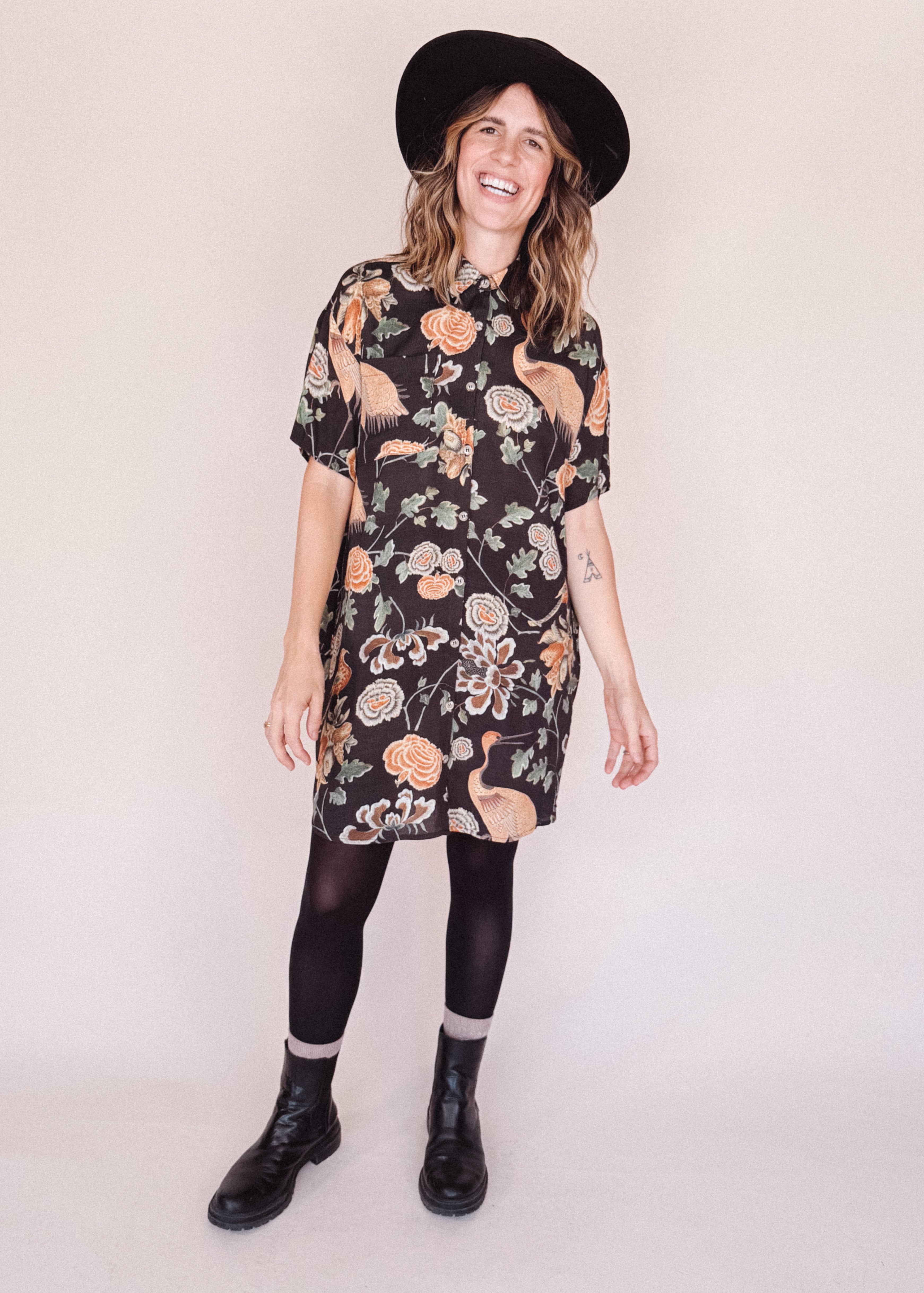 Woman wearing crane-print short sleeve button-up mini shirt dress with collar and side pockets