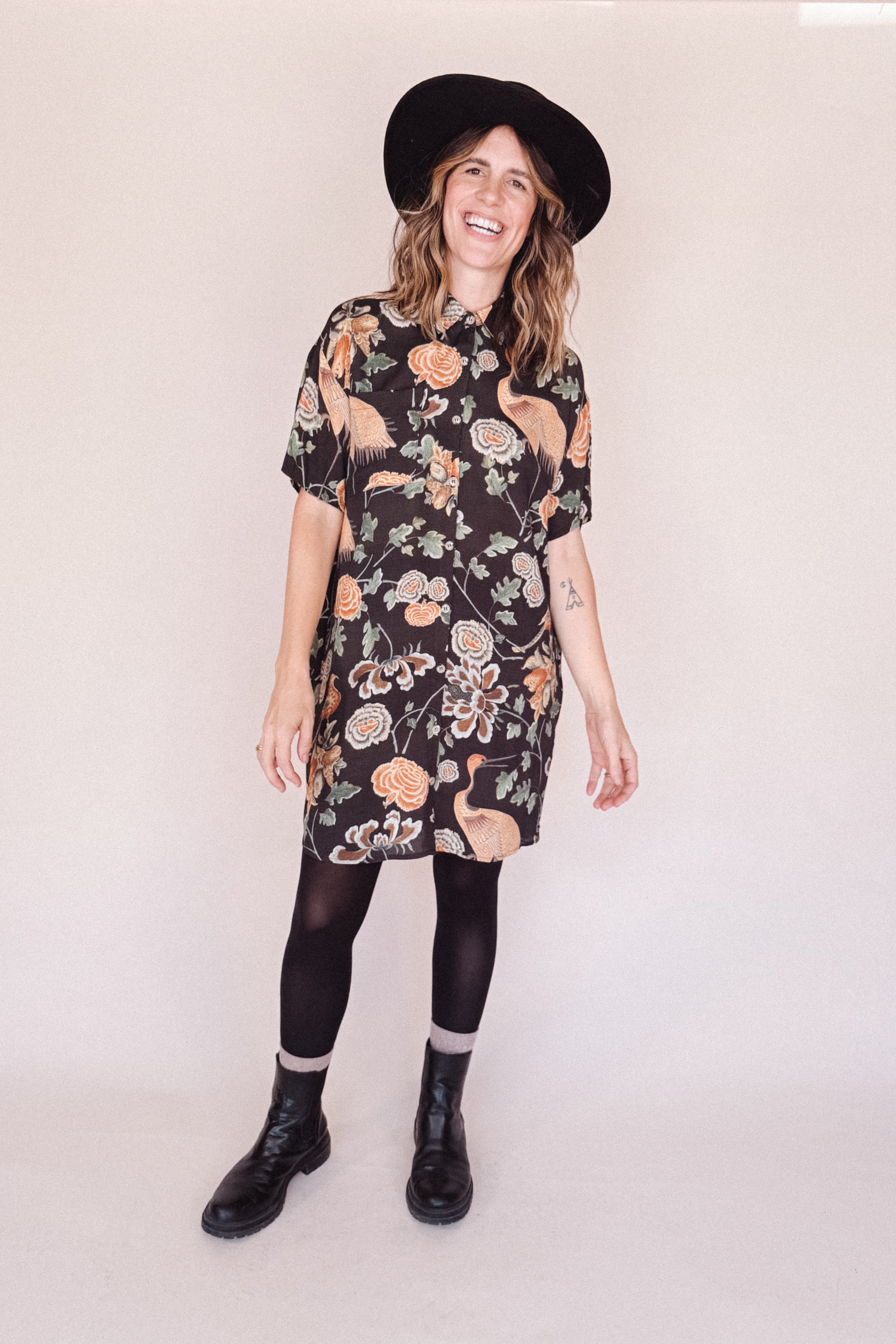 Woman wearing crane-print short sleeve button-up mini shirt dress with collar and side pockets