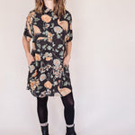 Woman wearing crane-print short sleeve button-up mini shirt dress with collar and side pockets