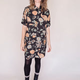 Woman wearing crane-print short sleeve button-up mini shirt dress with collar and side pockets