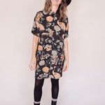 Woman wearing crane-print short sleeve button-up mini shirt dress with collar and side pockets with hat