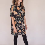 Woman wearing crane-print short sleeve button-up mini shirt dress with collar and side pockets