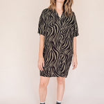 Woman wearing a zebra pattern dress against a plain background