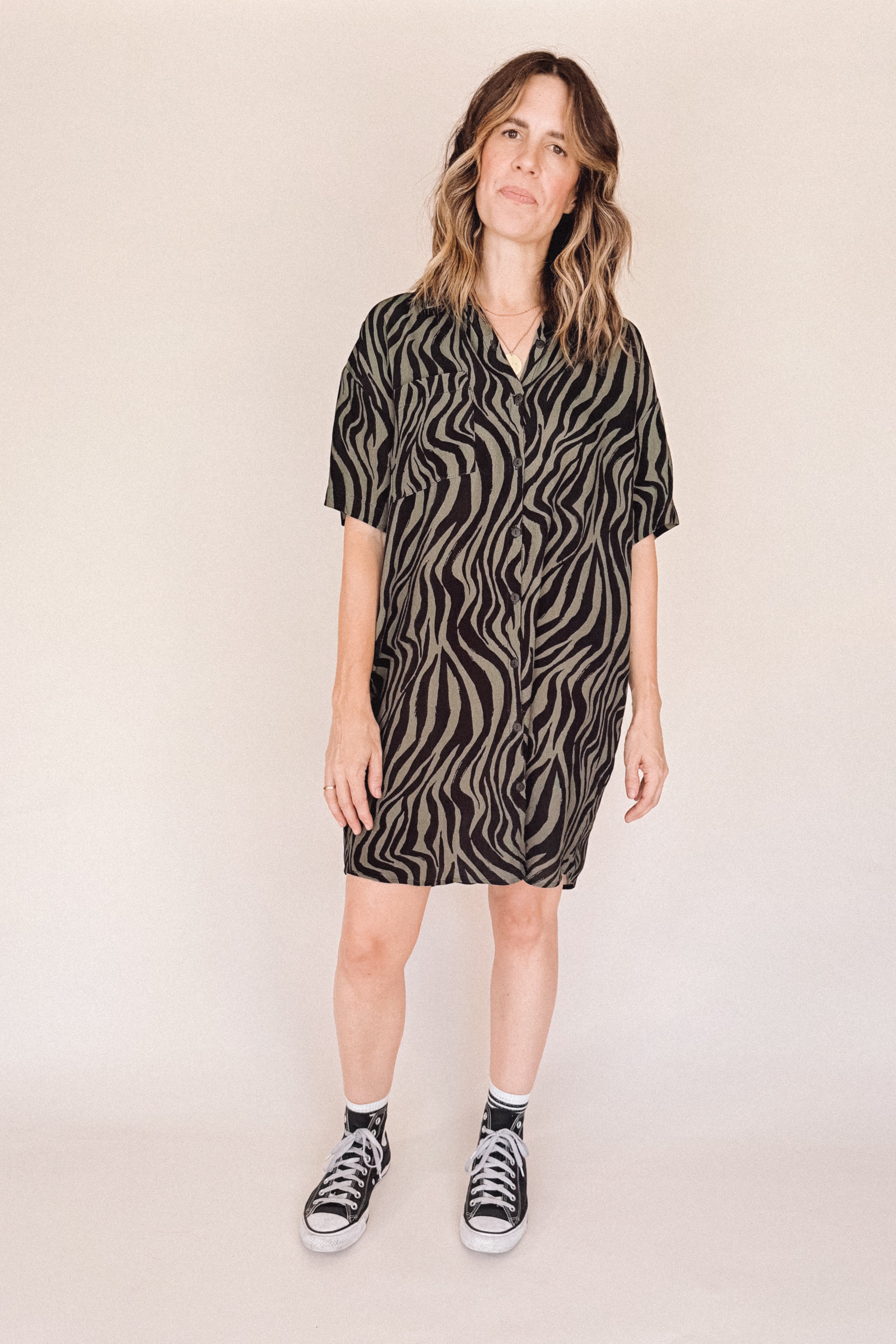 Woman wearing a zebra pattern dress against a plain background