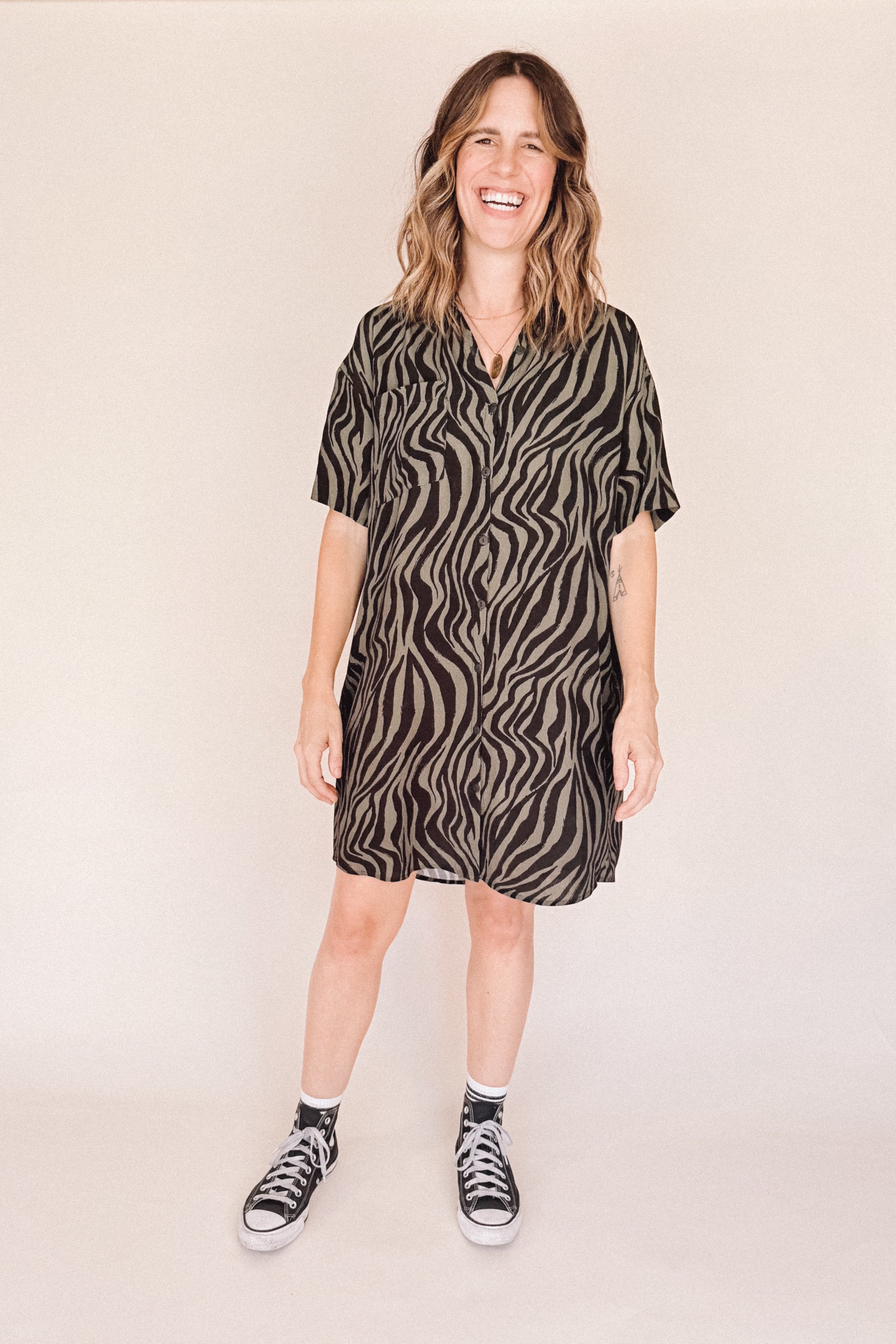 Woman wearing a zebra pattern dress on a beige background