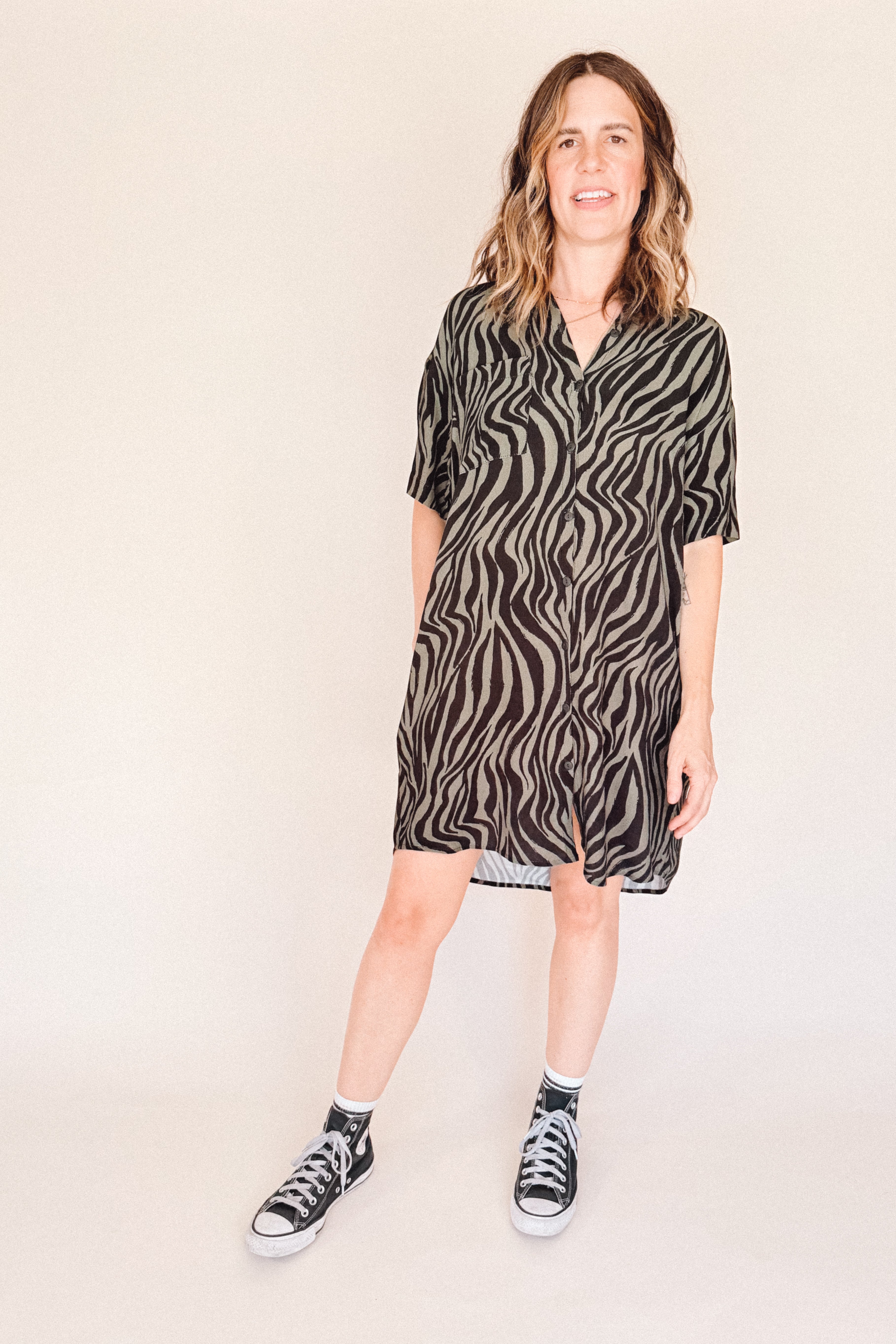 Person wearing a zebra patterned dress on a plain background