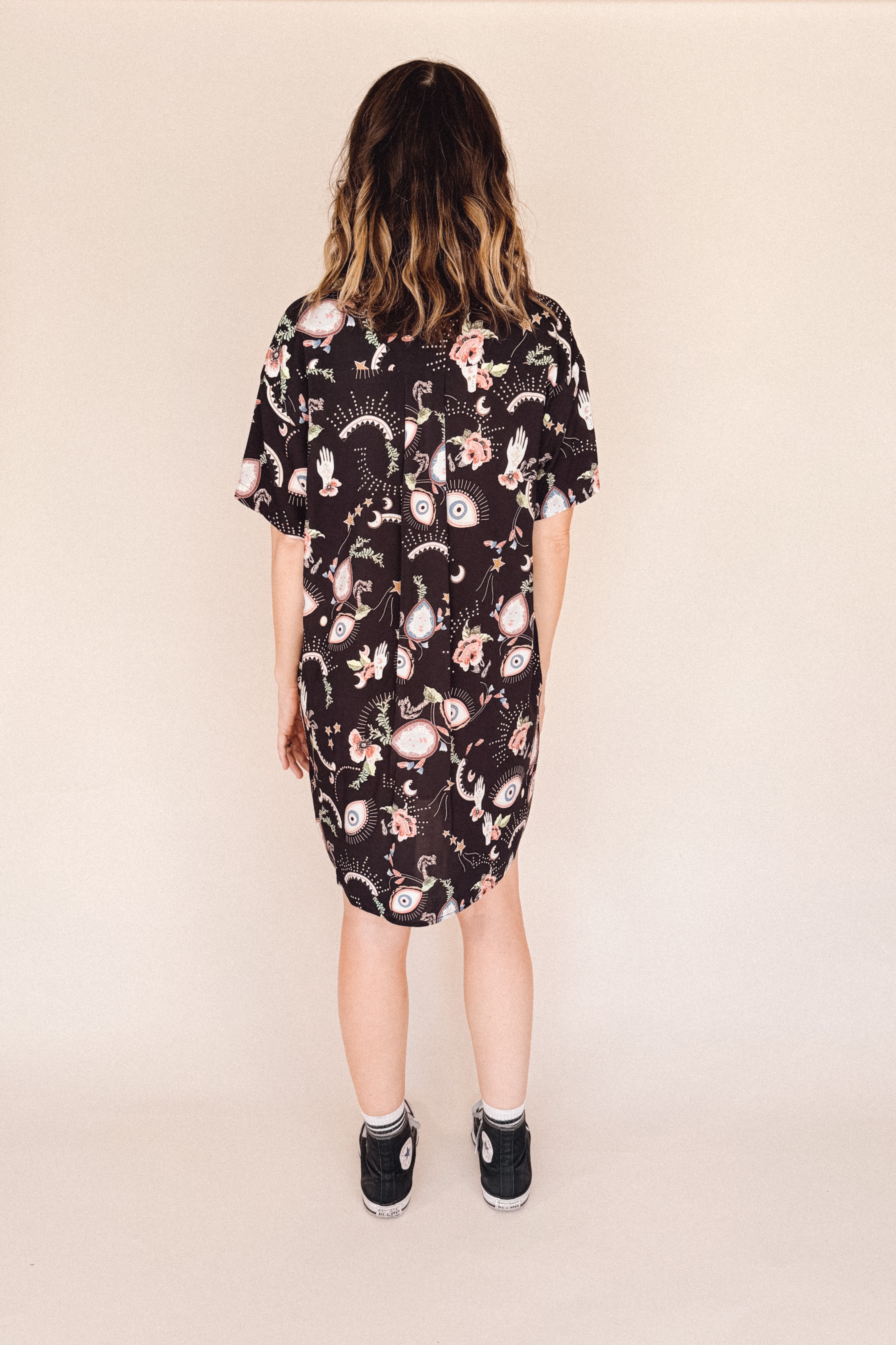woman wearing euye printed shirt dress back view