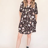 women with hands in side pockets of mini dress eye print shirt dress