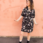 woman wearing casual button up with lace sleeve under layer eye ball print