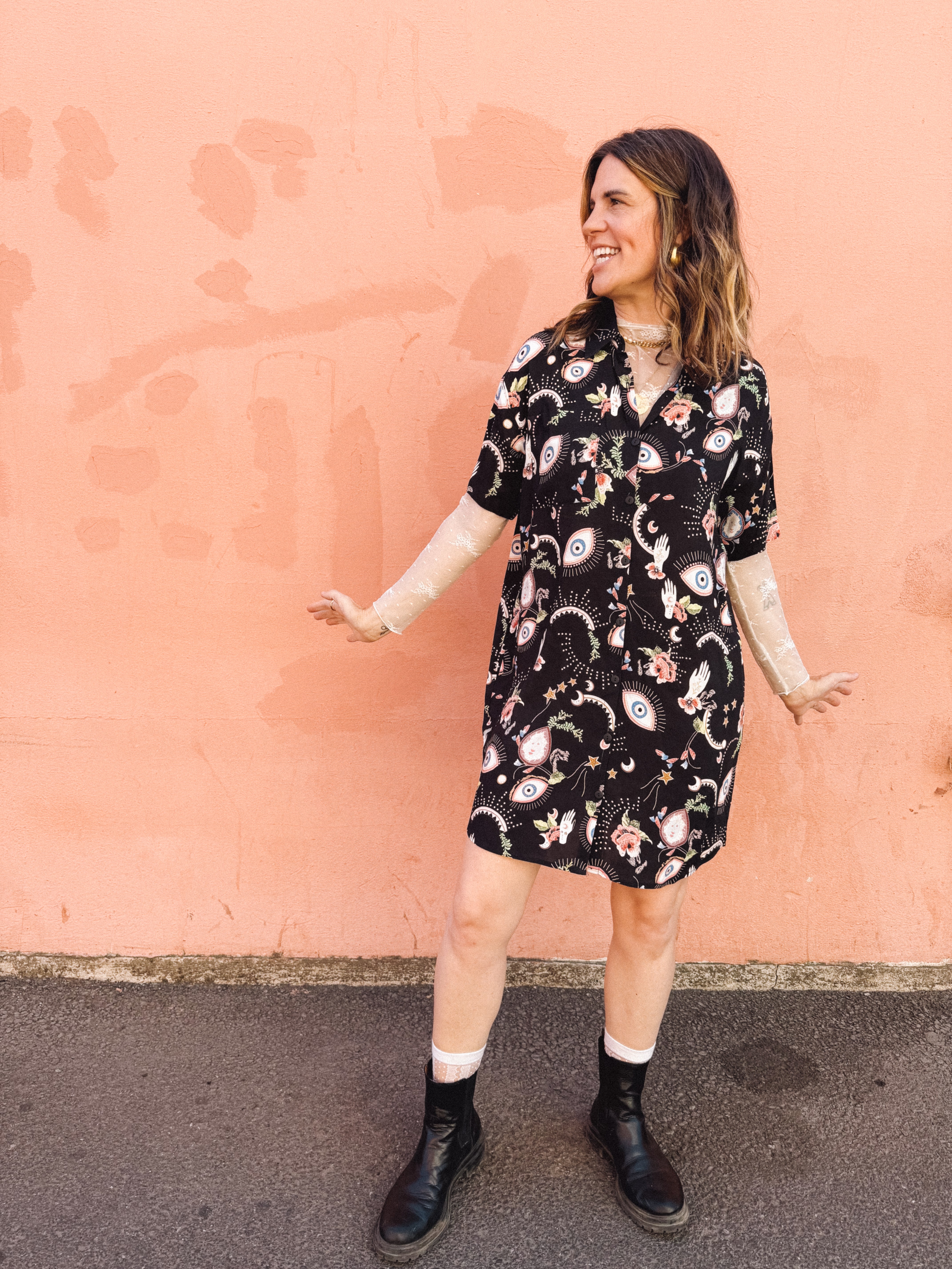 woman wearing casual button up with lace sleeve under layer eye ball print