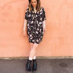 woman wearing mistic eye printed button up mini dress, relaxed shirt dress