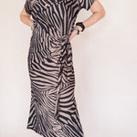 Person wearing a zebra print dress against a white background