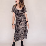 Woman wearing a zebra print dress against a plain background