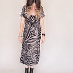 Person wearing a zebra print dress with a plain background