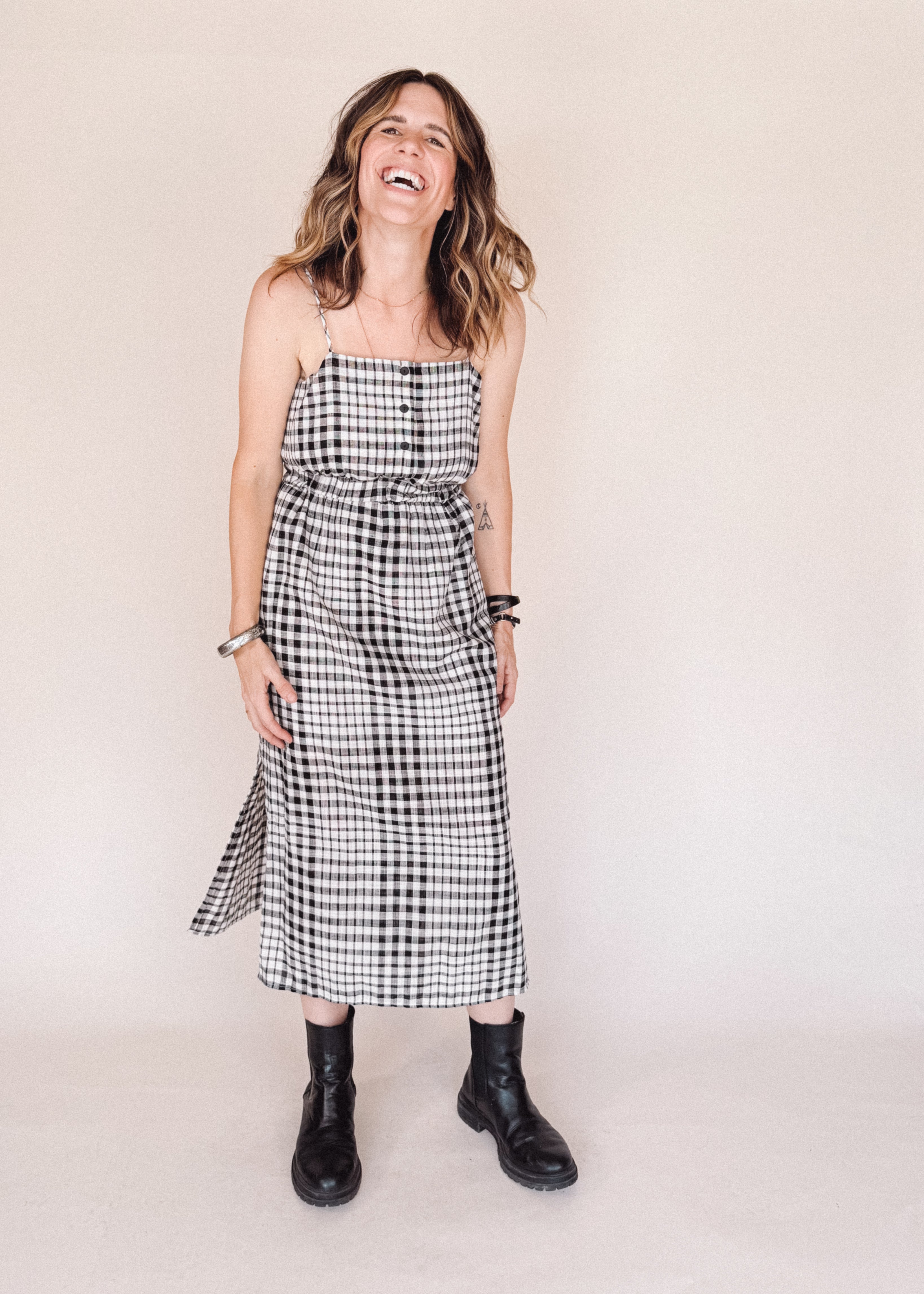 Woman wearing a black and white checkered dress against a plain background