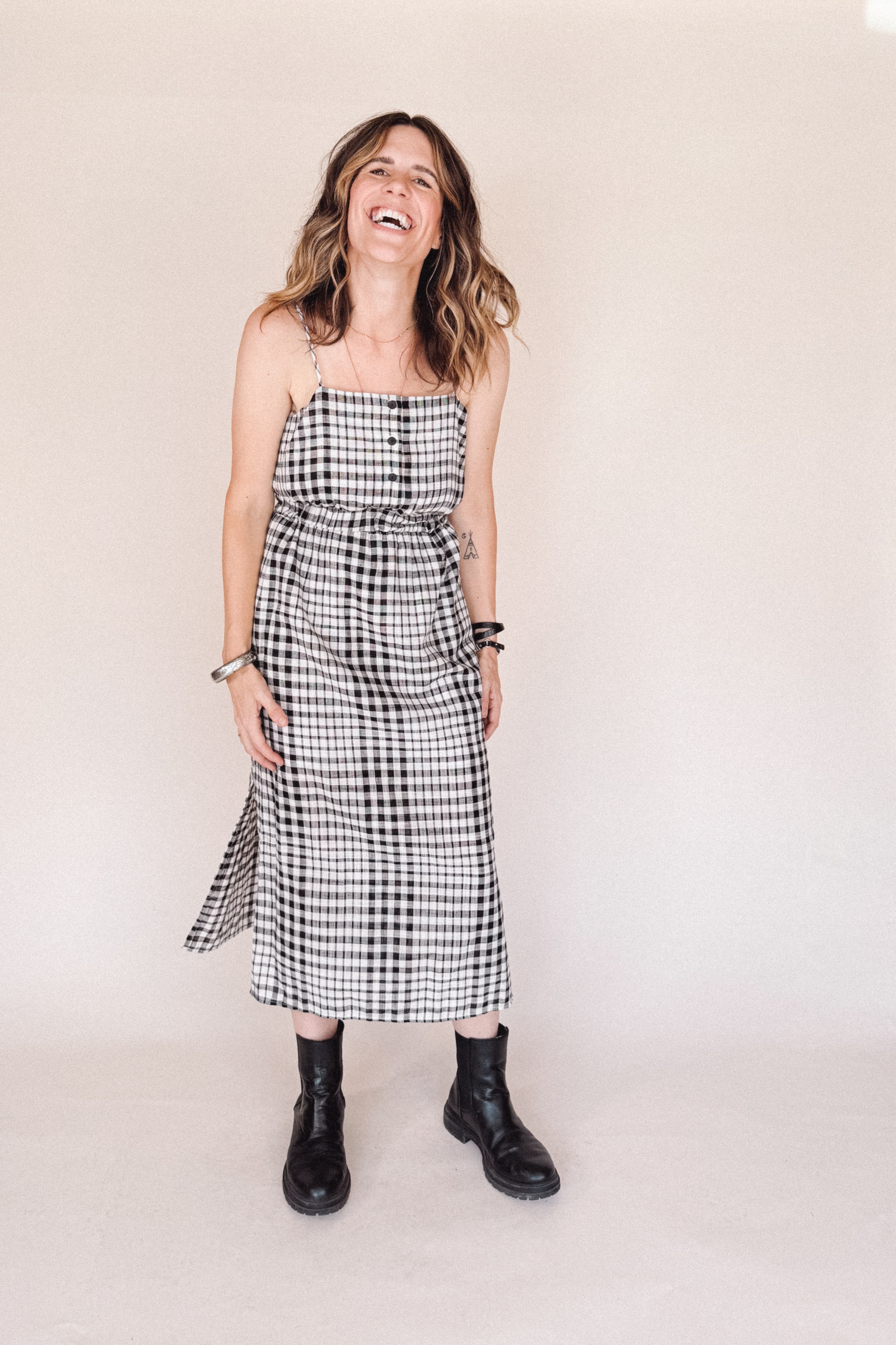 Woman wearing a black and white checkered dress against a plain background
