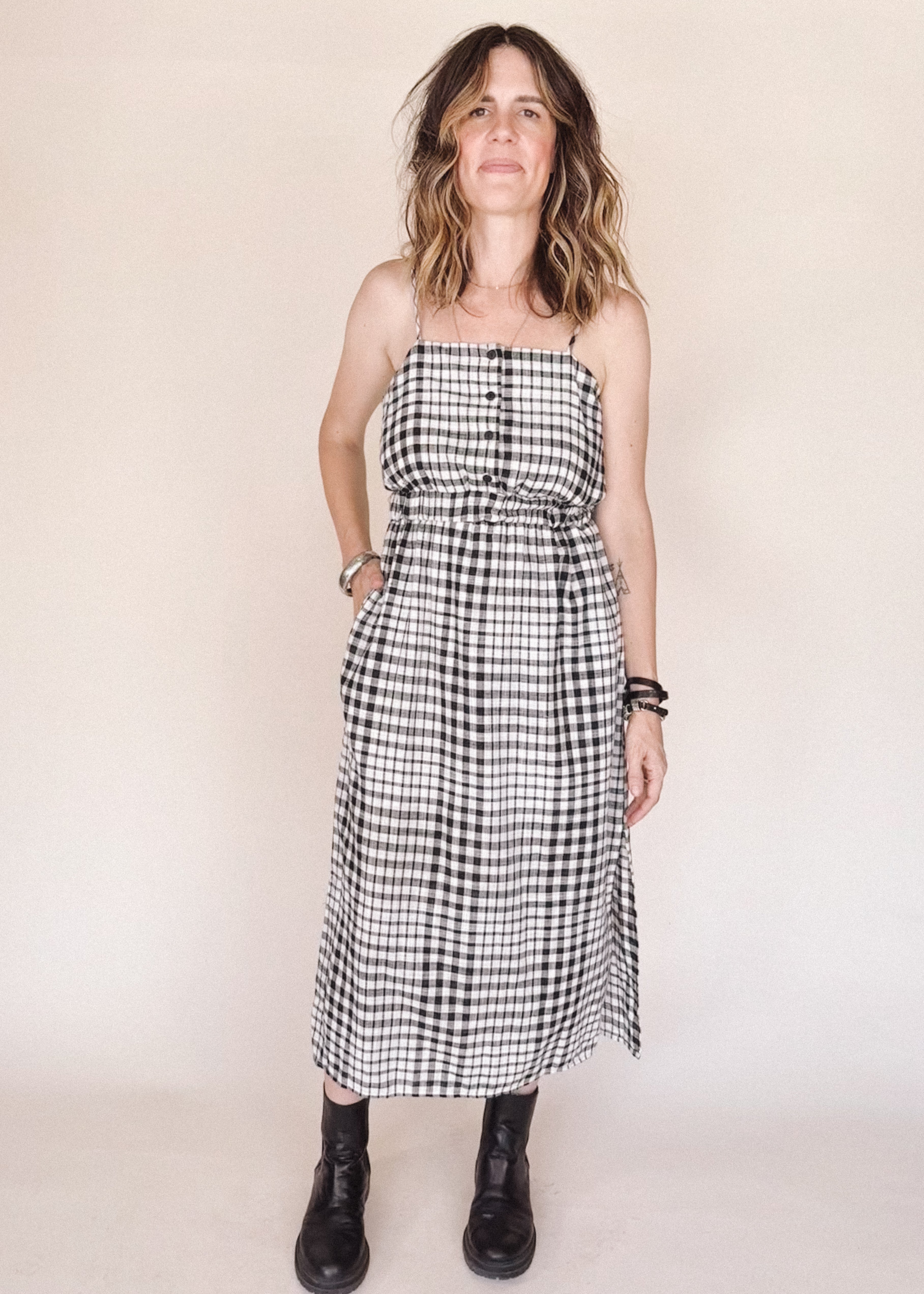 Woman wearing a black and white checkered dress against a plain background