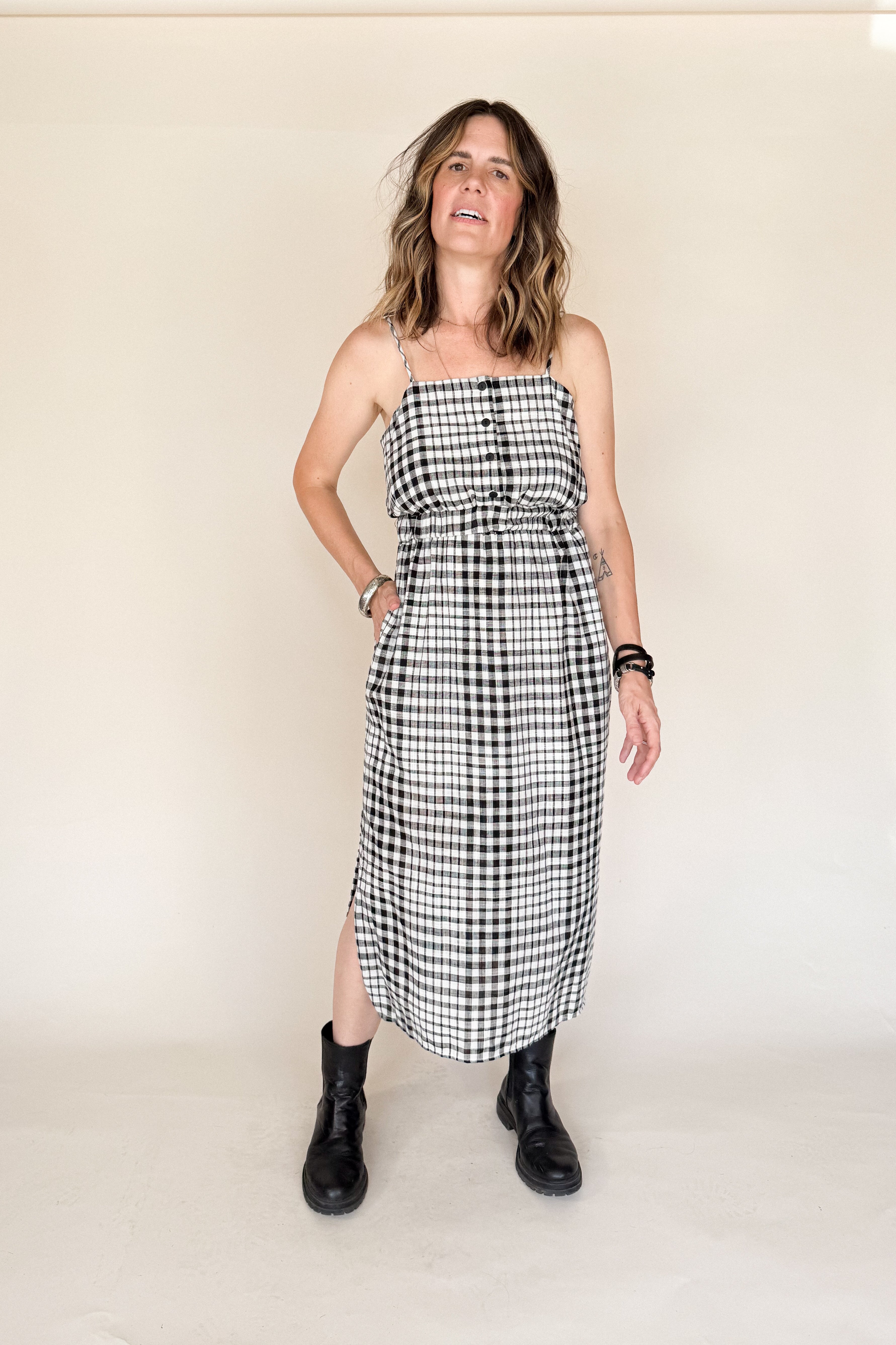Woman wearing a black and white checkered dress against a plain background