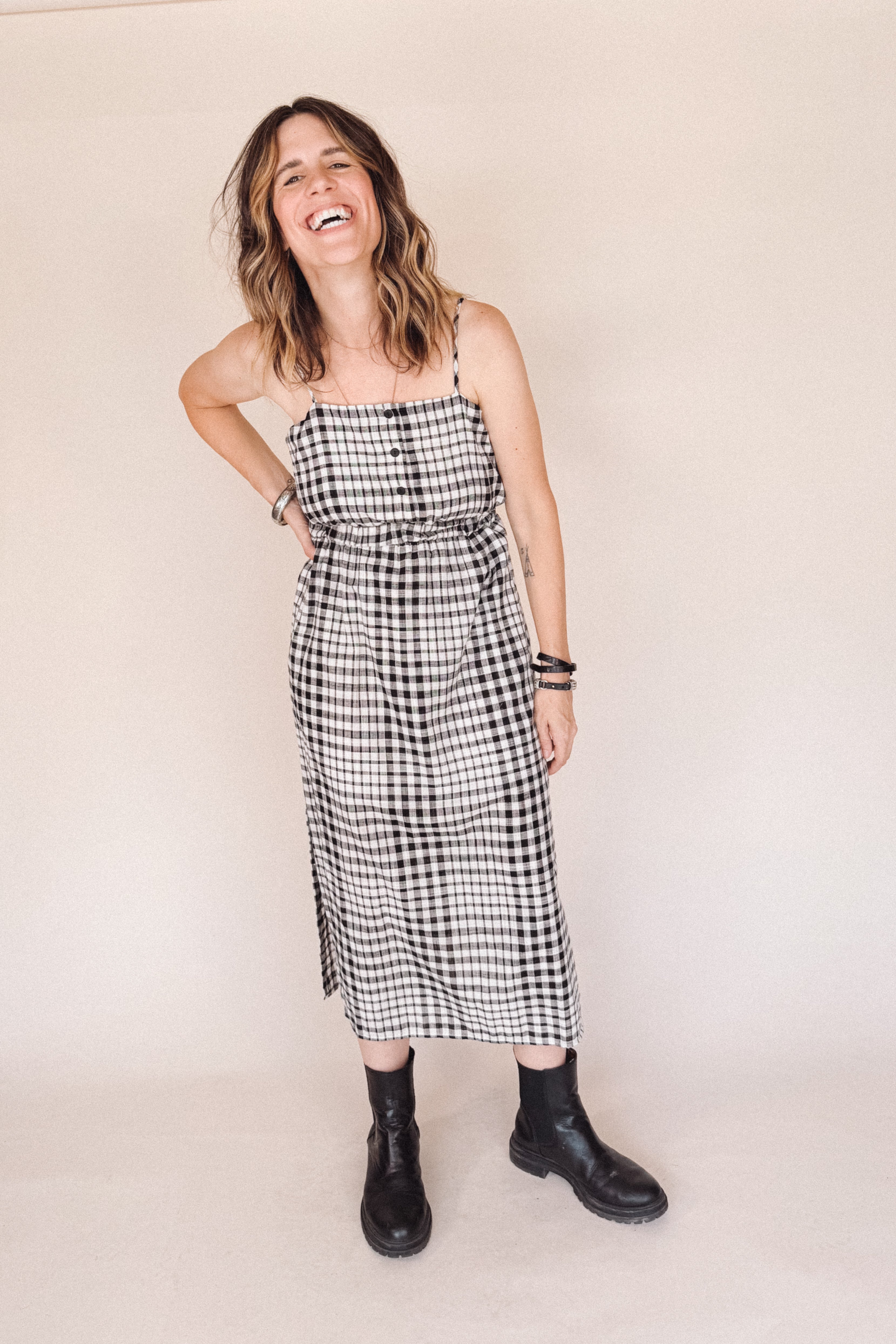 Woman wearing a black and white checkered dress against a beige background