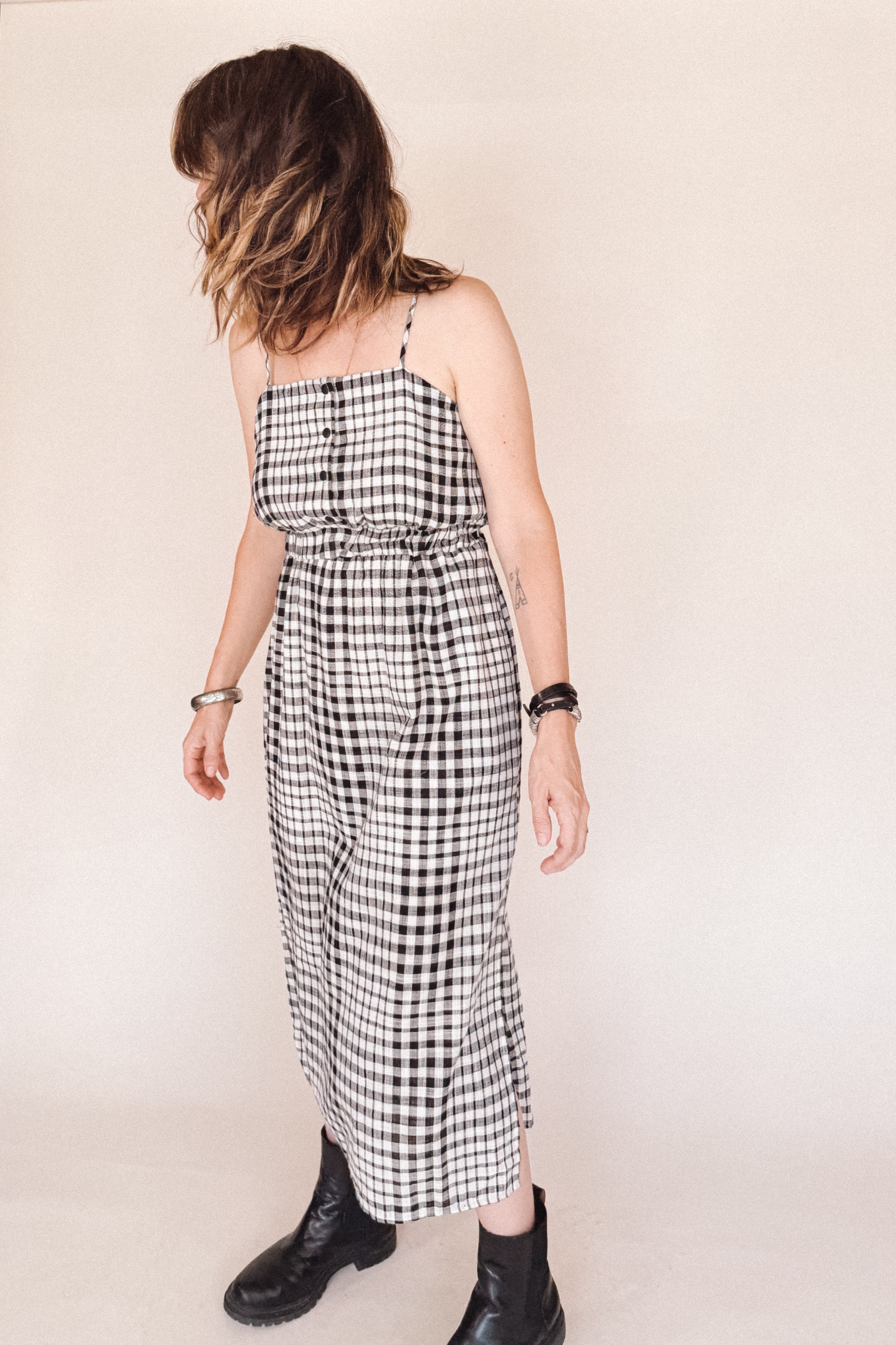 Woman wearing a black and white checkered dress against a plain background